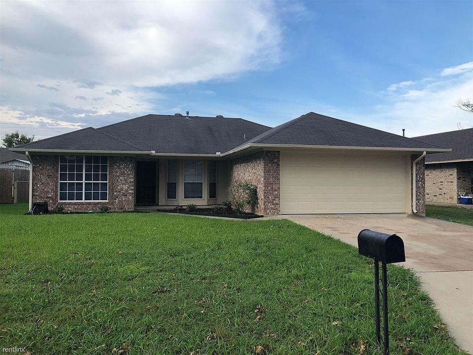 Ranch-style house featuring driveway, a garage, a front yard, and brick siding