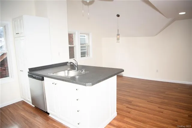 a kitchen with a sink cabinets and wooden floor