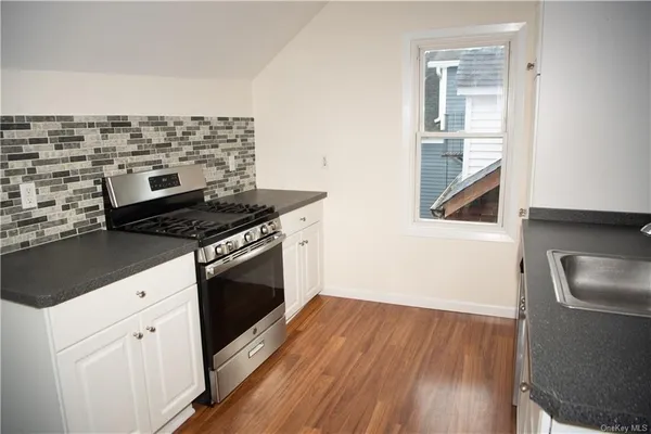 a kitchen with granite countertop a stove and a sink