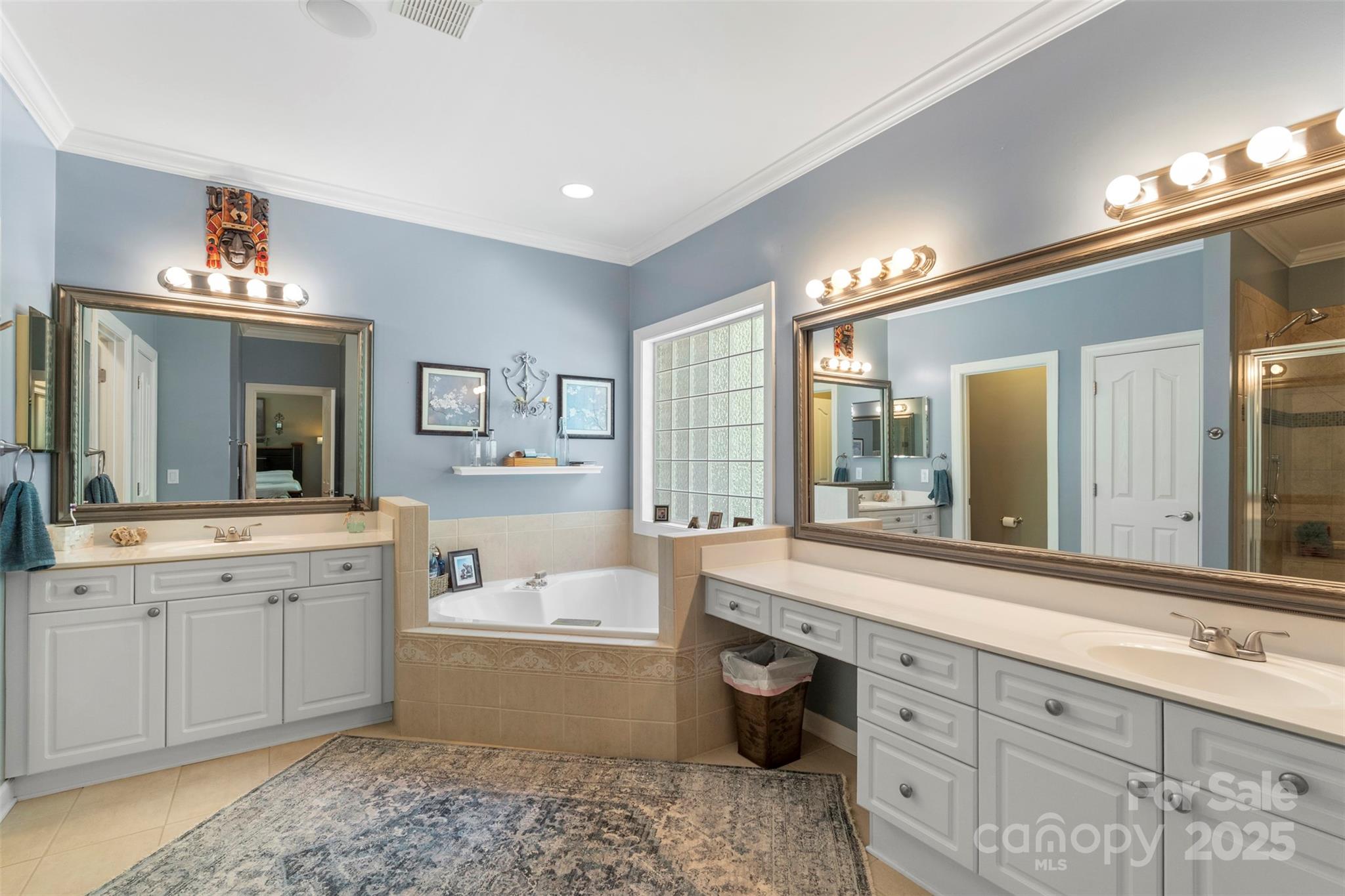 6006 Casswell Circle Matthews, NC 28104 - Photo 21 of 47 a spacious bathroom with a double vanity sink a large mirror and a bathtub