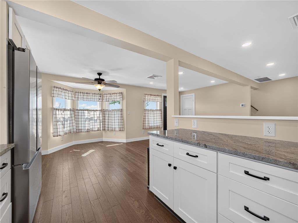 291 East Dannersville Road Bath, PA 18014 - Photo 34 of 46 A vibrant living area with rich wood flooring opens to a modern kitchen island, creating an inviting, flowing space.