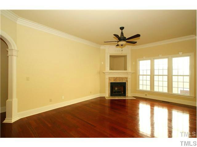7329 Newport Avenue Raleigh, NC 27613 - Photo 5 of 17 a view of a livingroom with a fireplace a ceiling fan and wooden floor