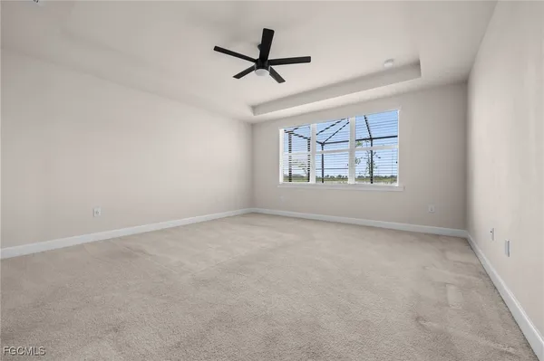 an empty room with windows and ceiling fan
