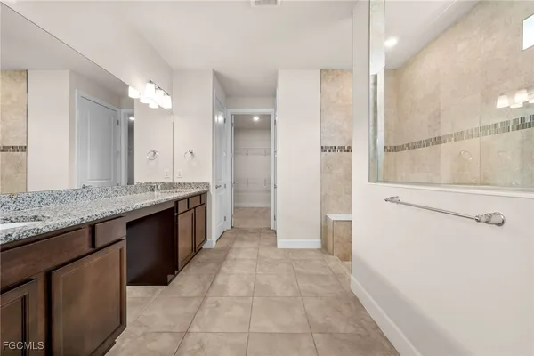 a large bathroom with a granite countertop sink a large mirror and shower