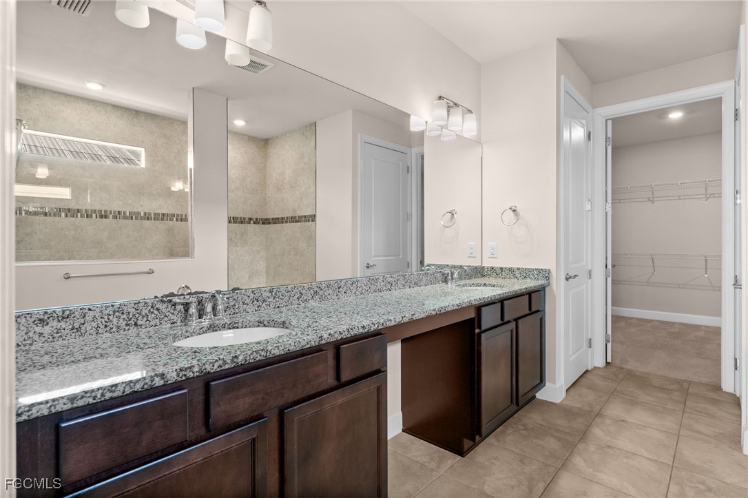42346 Waterfront Way Punta Gorda, FL 33982 - Photo 24 of 46 a bathroom with a granite countertop sink a large mirror and a shower