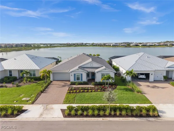a front view of a house with a yard and lake view