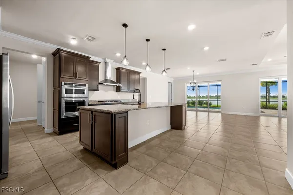 a large kitchen with stainless steel appliances granite countertop a large counter top a sink and a stove