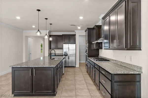 a kitchen with a stove kitchen island a refrigerator and a sink
