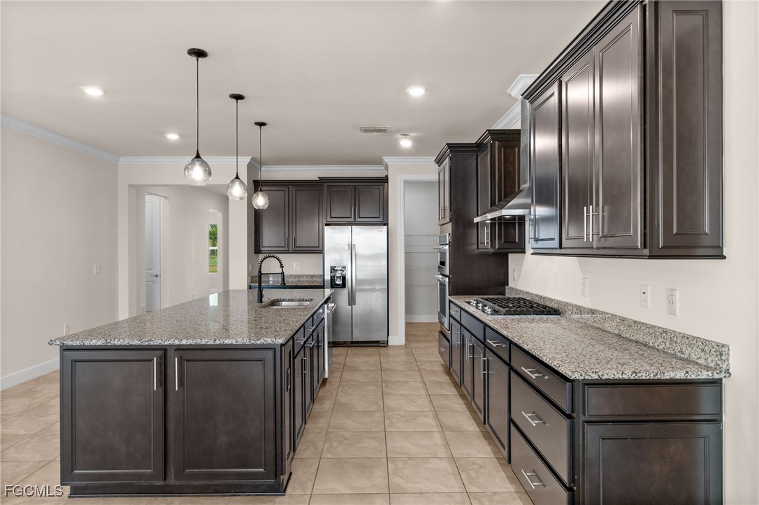 42346 Waterfront Way Punta Gorda, FL 33982 - Photo 9 of 46 a kitchen with a stove kitchen island a refrigerator and a sink