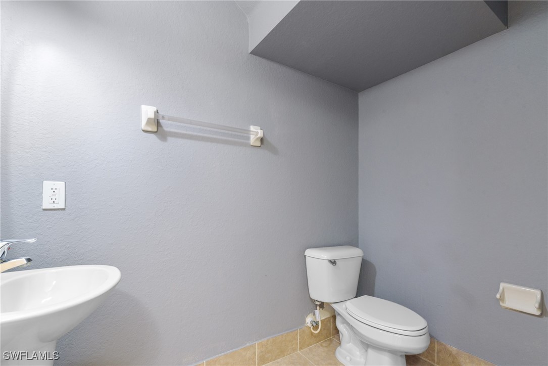 4031 Cherrybrook Loop Fort Myers, FL 33966 - Photo 20 of 34 a bathroom with a toilet a sink and mirror
