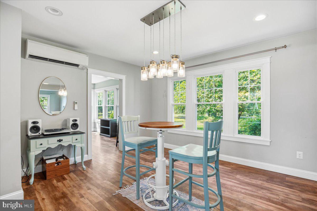 16146 Thomas Road Piney Point, MD 20674 - Photo 18 of 70 a view of a dining room with furniture a chandelier and wooden floor