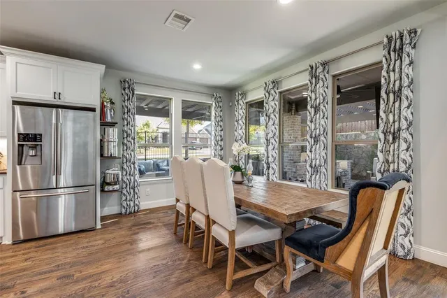 a kitchen that has a lot of cabinets in it and wooden floors
