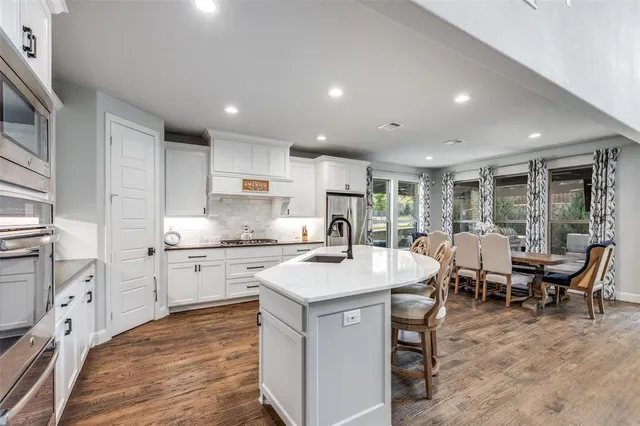 a kitchen with stainless steel appliances granite countertop a refrigerator and a stove top oven