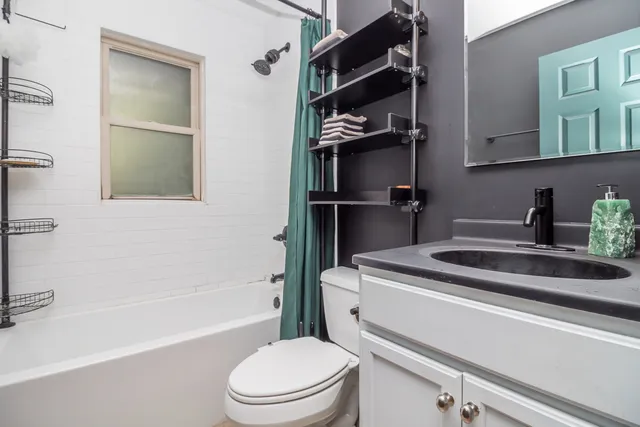 a bathroom with a granite countertop sink toilet and shower