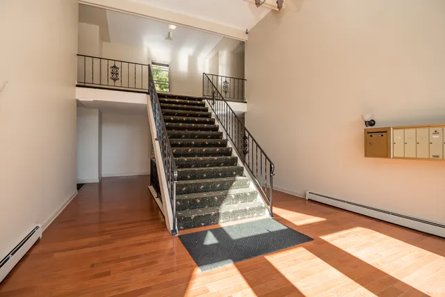 a view of entryway and hall with wooden floor