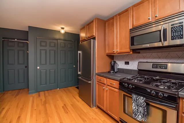 a kitchen with stainless steel appliances granite countertop a stove refrigerator and microwave