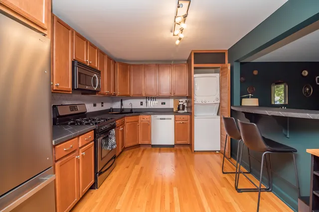 a kitchen with stainless steel appliances granite countertop wooden cabinets a stove top oven a sink and dishwasher