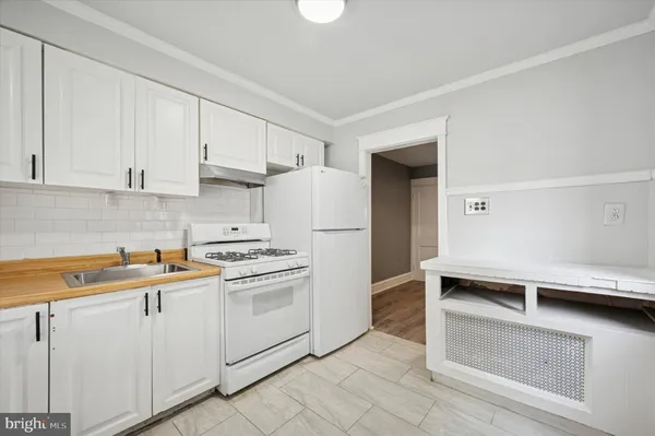 a kitchen with white cabinets and white appliances