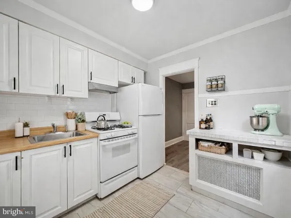 a kitchen with stainless steel appliances granite countertop white refrigerator a stove a sink and white cabinets