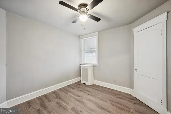 an empty room with a window and a ceiling fan