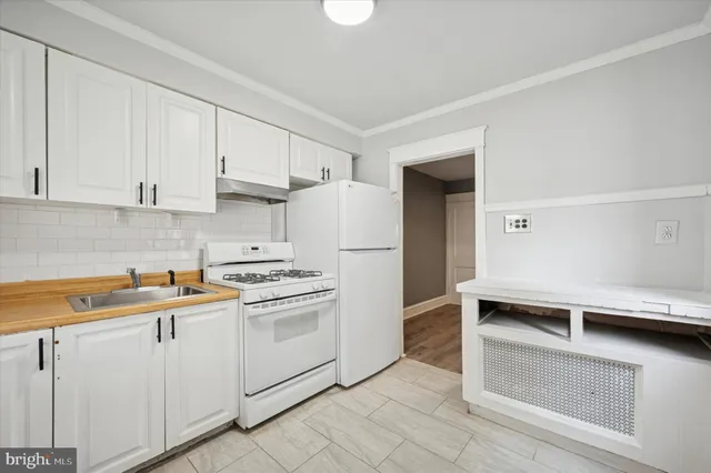 a kitchen with white cabinets and white appliances