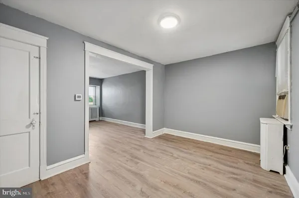 an empty room with wooden floor and mirror