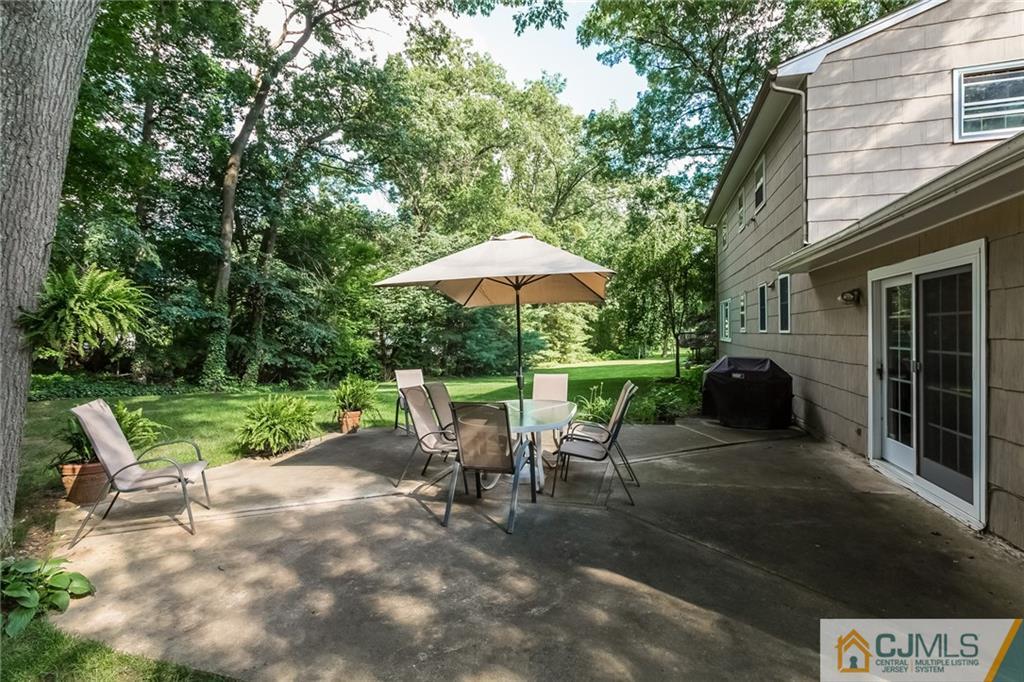 41 Rath Lane East Brunswick, NJ 08816 - Photo 22 of 24 a view of a patio with a table and chairs under an umbrella