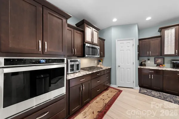 a kitchen with stainless steel appliances granite countertop a stove microwave and refrigerator