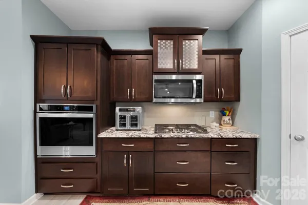 a kitchen with granite countertop wooden cabinets and stainless steel appliances