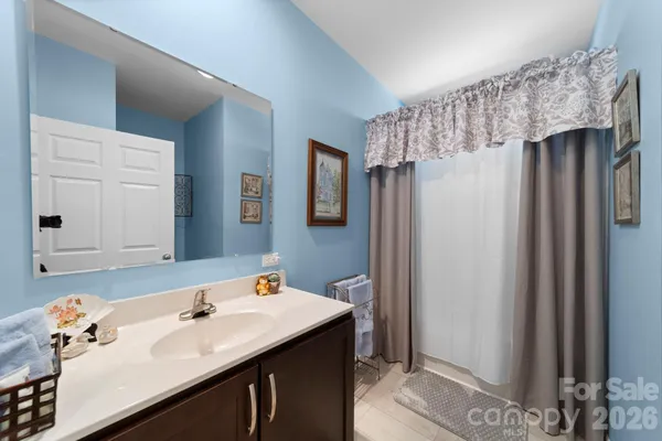 a bathroom with a sink vanity granite tub shower and a mirror