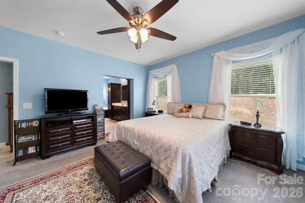 a spacious bedroom with a bed and a flat screen television