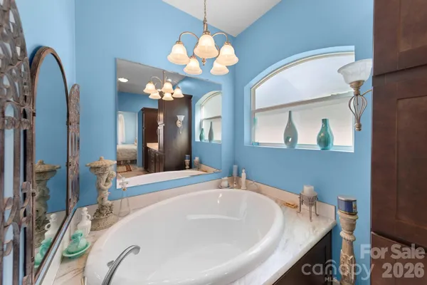 a spacious bathroom with a granite countertop sink a mirror and a bathtub