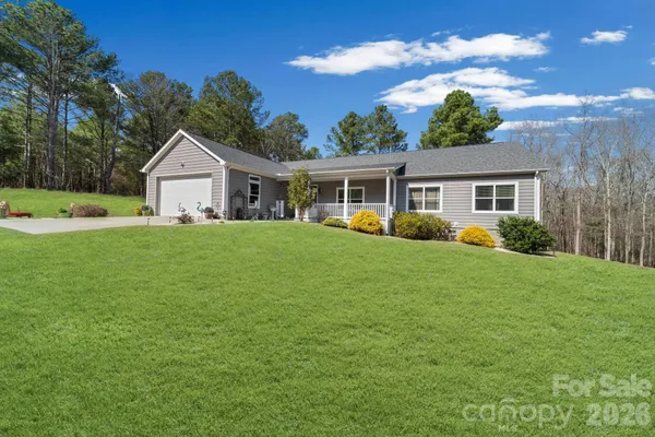 a view of a house with a big yard and potted plants