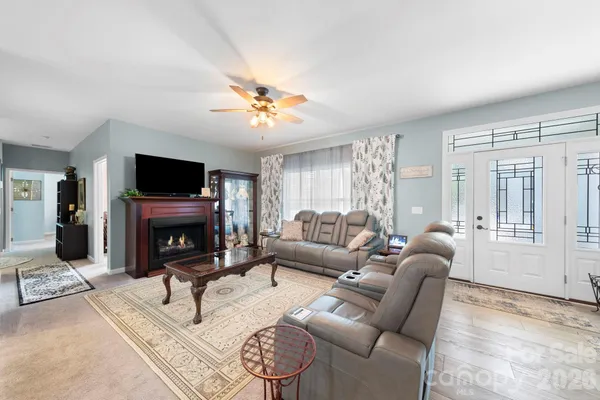 a living room with furniture a fireplace and a flat screen tv