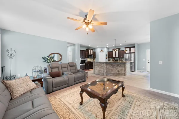 a living room with furniture and kitchen view