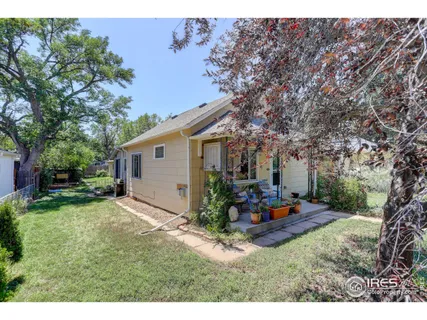 a backyard of a house with table and chairs