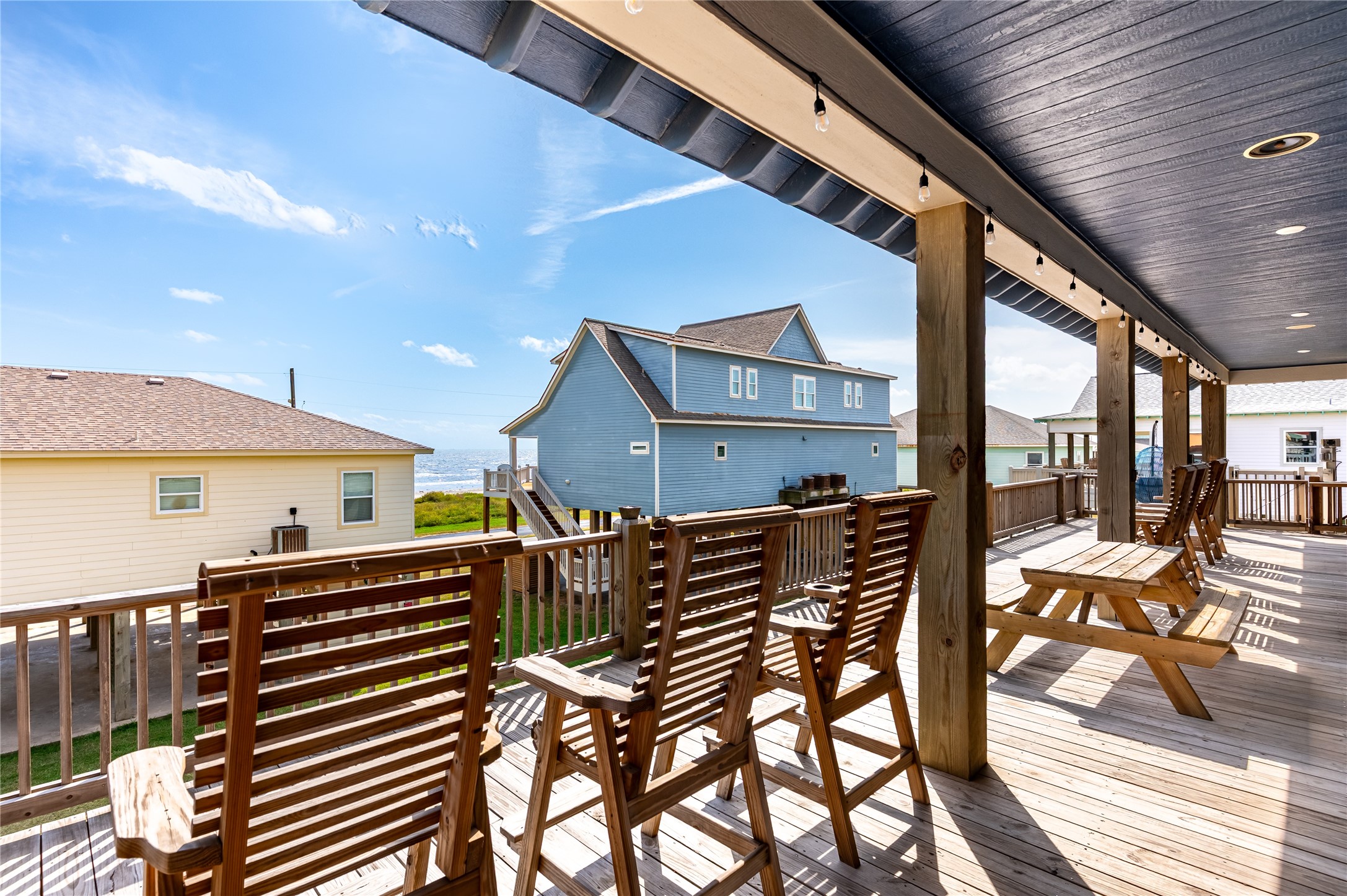 2576 Whitecap Crystal Beach, TX 77650 - Photo 11 of 49 a view of a patio with table and chairs with wooden floor and fence