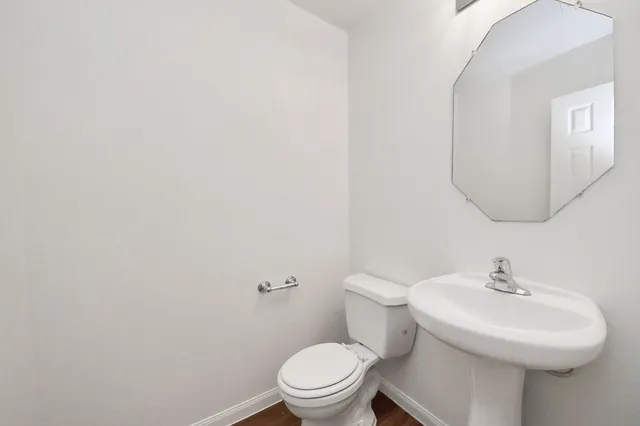 a bathroom with a sink a toilet and a mirror