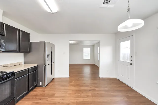 a view of a kitchen center island with stainless steel appliances wooden floor and a window
