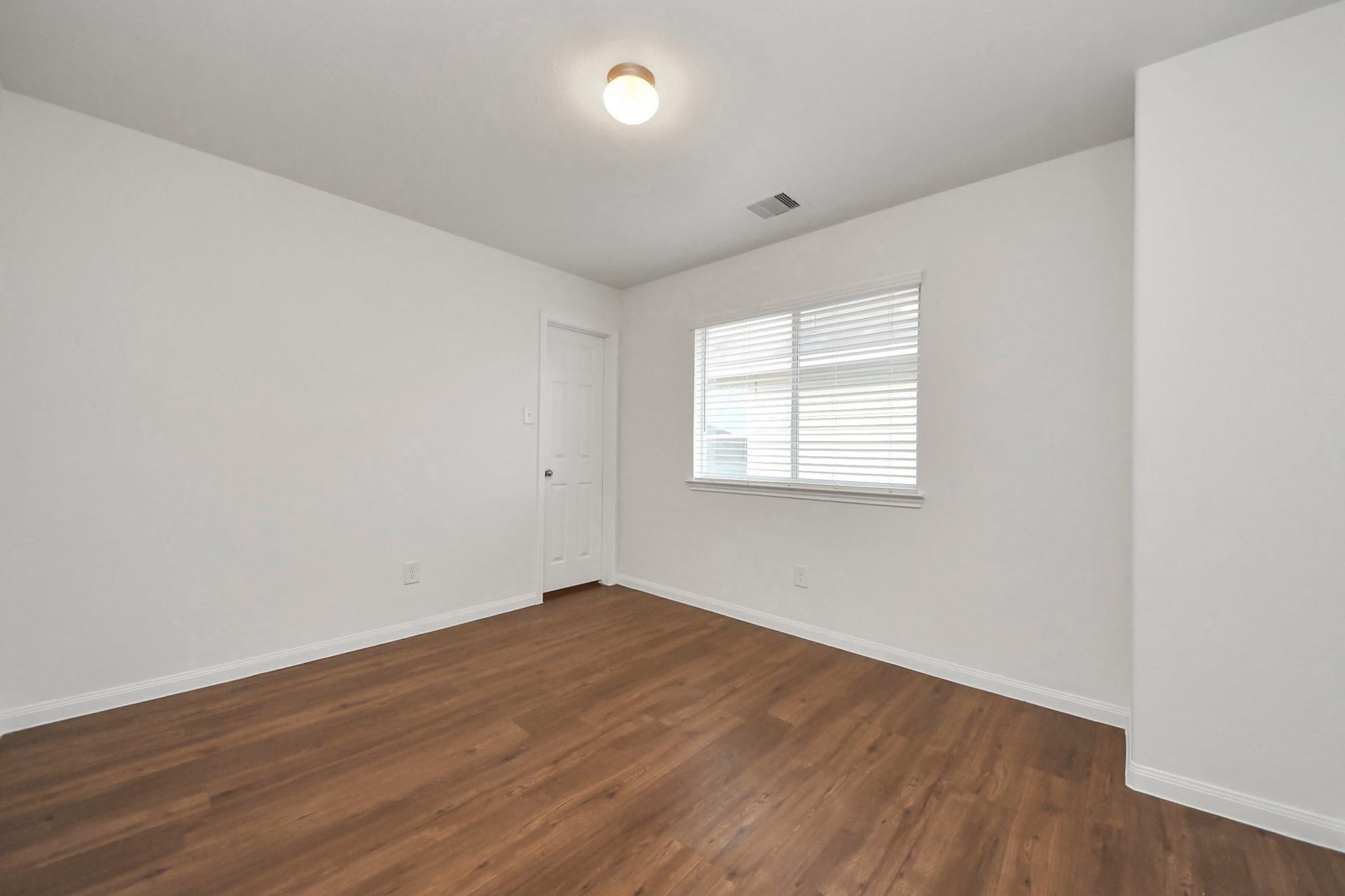 886 Darbydale Crossing Lane Houston, TX 77090 - Photo 26 of 41 an empty room with wooden floor and windows