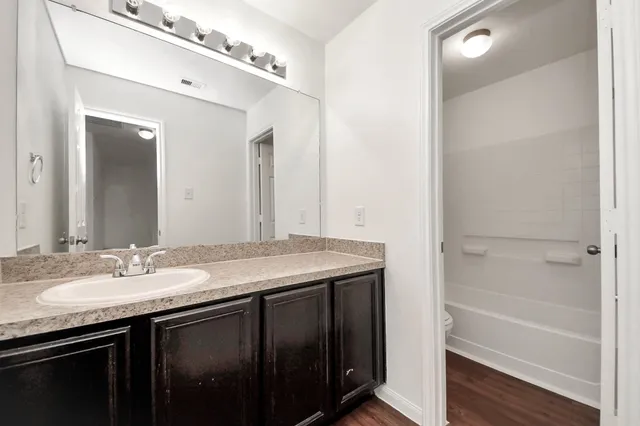 a bathroom with a granite countertop sink tub and a mirror