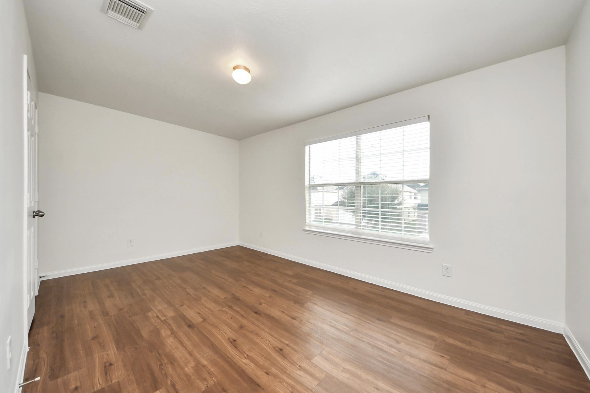 886 Darbydale Crossing Lane Houston, TX 77090 - Photo 31 of 41 an empty room with wooden floor and windows