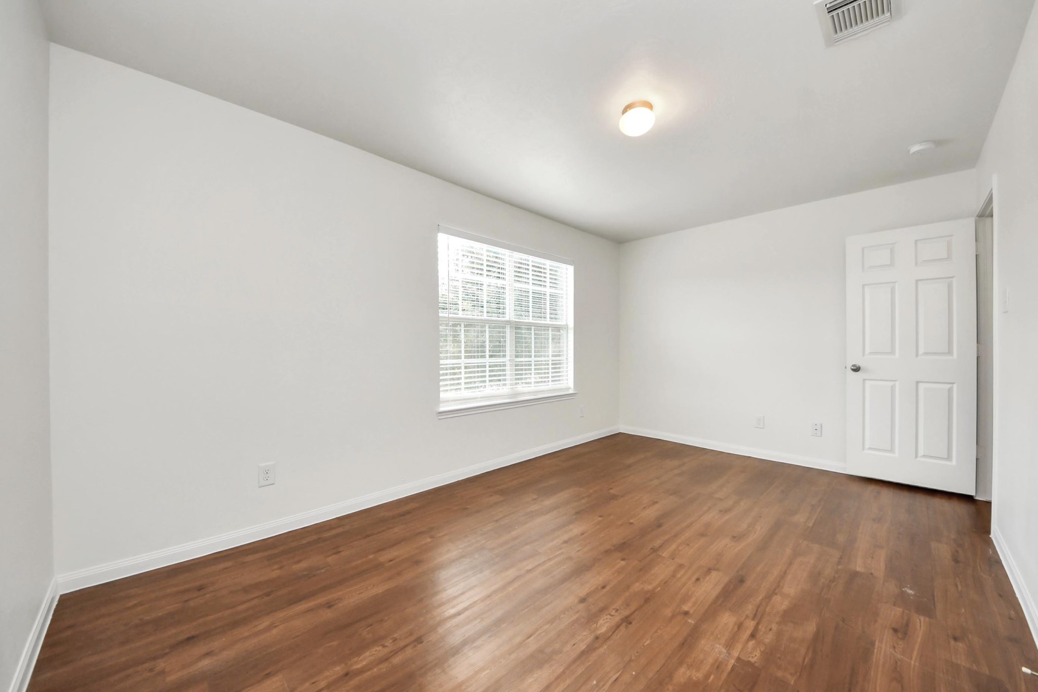 886 Darbydale Crossing Lane Houston, TX 77090 - Photo 32 of 41 an empty room with wooden floor and windows