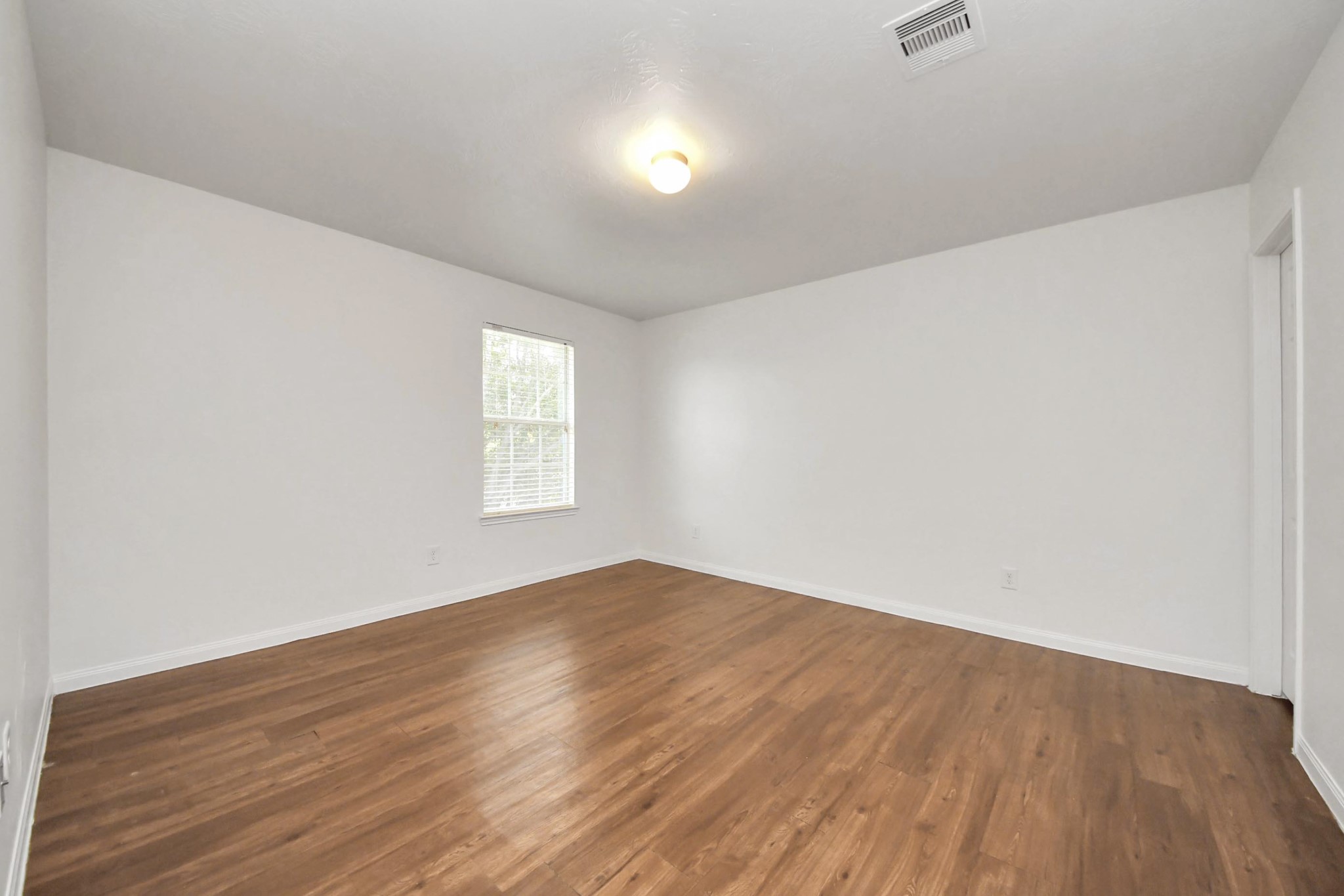 886 Darbydale Crossing Lane Houston, TX 77090 - Photo 33 of 41 an empty room with wooden floor and windows
