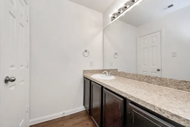 a bathroom with a granite countertop sink and dishwasher