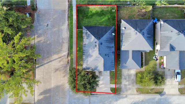 an aerial view of a house with a yard and large trees