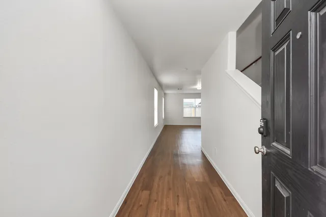 a view of a hallway with wooden floor and staircase