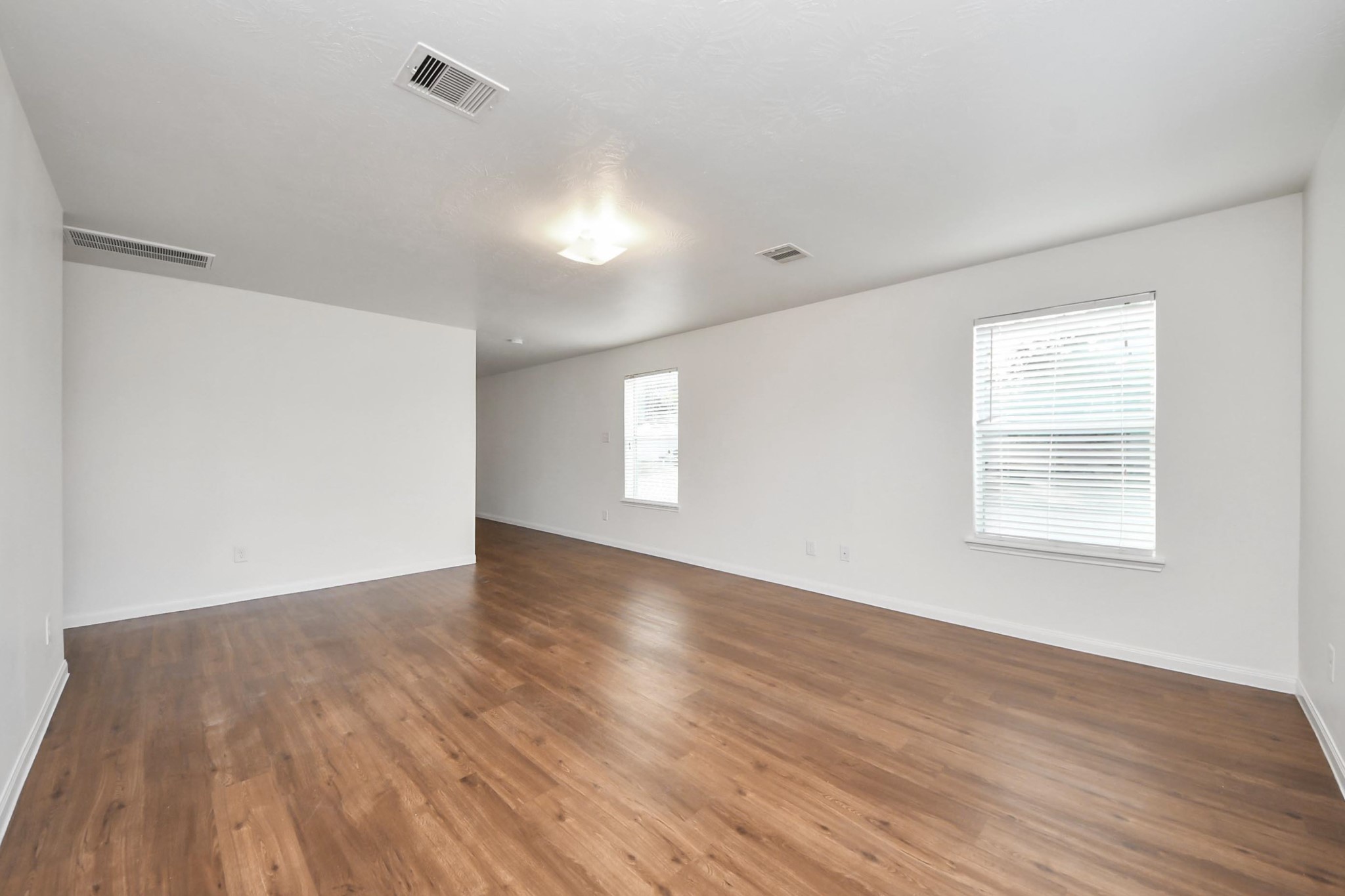 886 Darbydale Crossing Lane Houston, TX 77090 - Photo 8 of 41 an empty room with wooden floor and windows