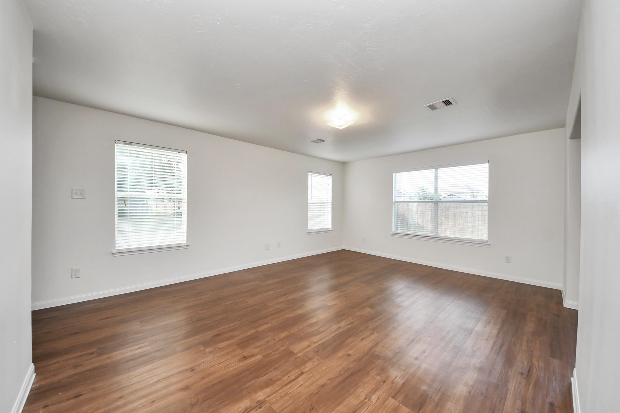 886 Darbydale Crossing Lane Houston, TX 77090 - Photo 9 of 41 an empty room with wooden floor and windows