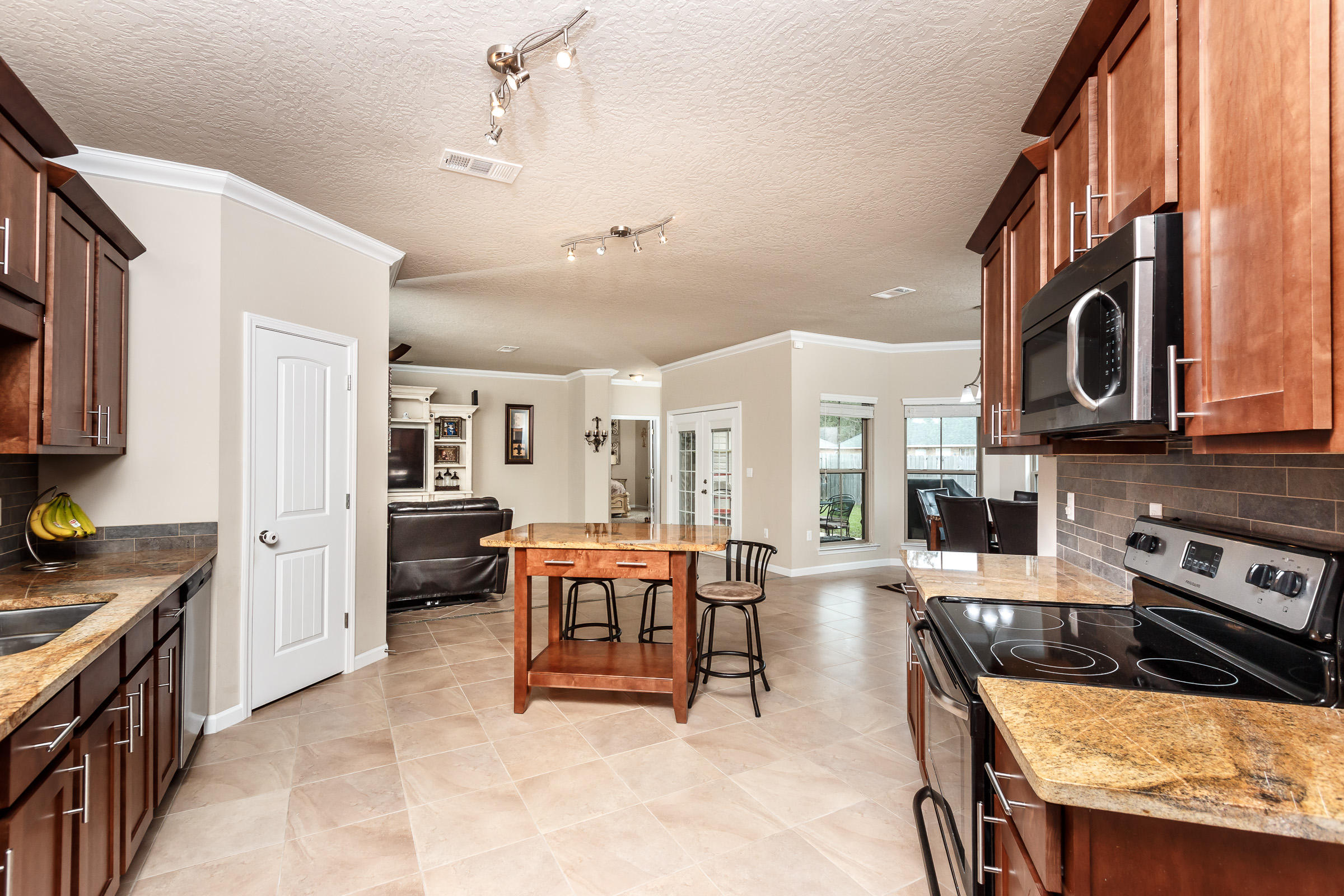 4600 Hermosa Road Crestview, FL 32539 - Photo 3 of 40 a kitchen with stainless steel appliances granite countertop a stove top oven a sink a dining table and chairs with wooden floor
